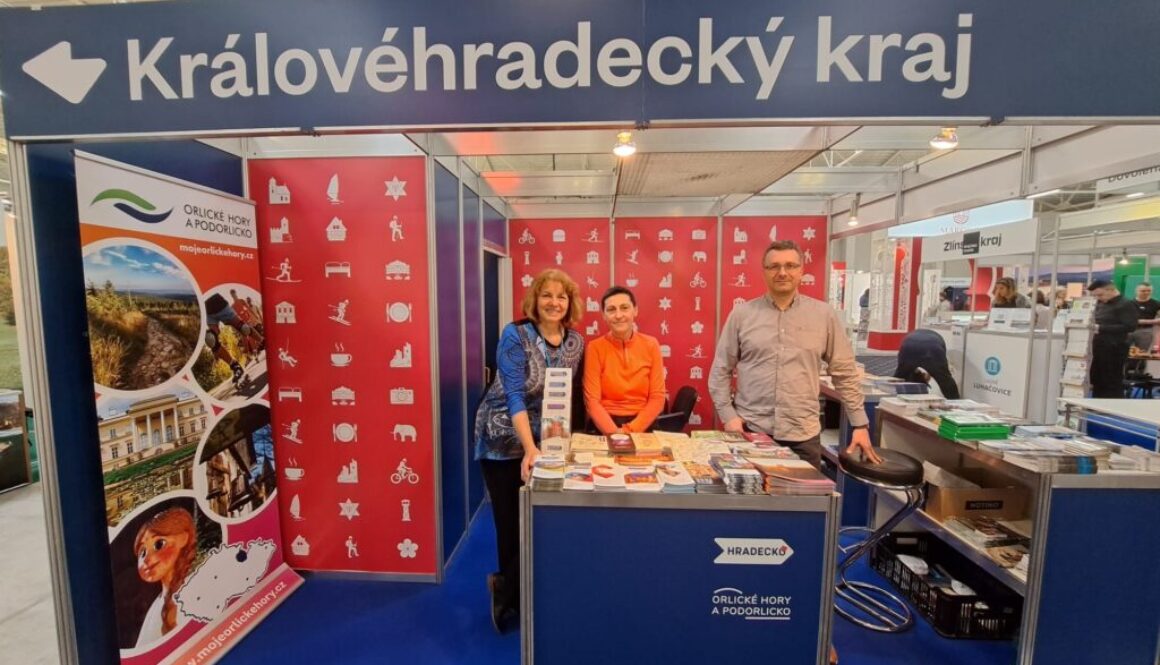 Modročervený stánek s nápisem Královéhradecký kraj a třemi představiteli destinačních managementů